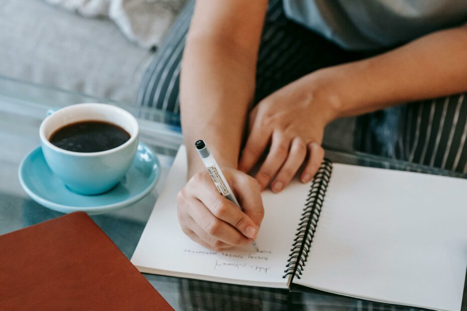 femme avec un café qui écrit sur une feuille